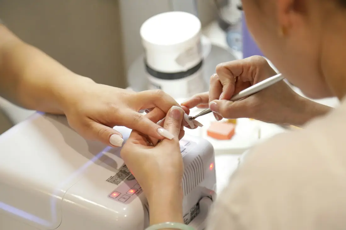 Stylistka paznokci wykonuje manicure
